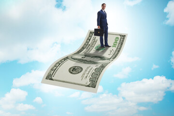 Businessman flying on hundred dollar banknote