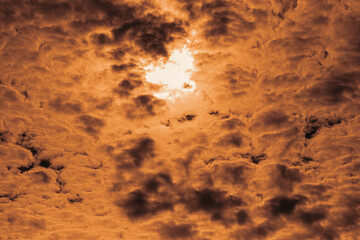 Orange clouds covered the sun disc. Cloudy landscape. Selective focus.