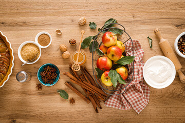 Ingredients for cooking Thanksgiving autumn apple pie with fresh fruits, cinnamon and walnuts on wooden table, top view