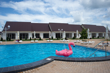 Inflatable flamingo in pool. Pool party, summer holidays, beach vacation. Fantasy swim ring for...