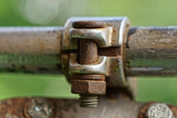 rusty iron bolt with nut on a metal rusty mount of an old bicycle handlebar