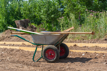 Construction trolley with tools on gravel. Backfilling of paths and paths.