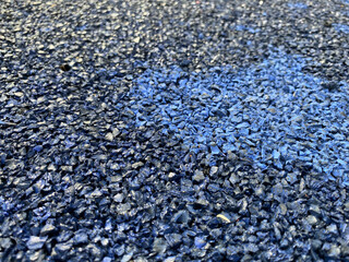 Blue rubber surface anti-traumatic safety tile on workout sports playground in public park or courtyard. The background. Texture
