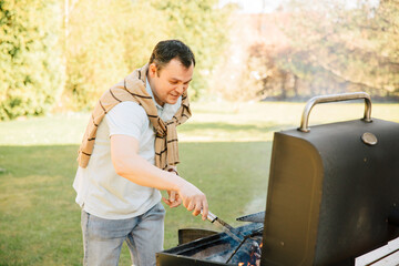 Man grilling with belly in the garden. Barbecue at home when the weather is nice. Prepare food outside	