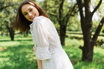 Pretty woman in summer dress smiling in park