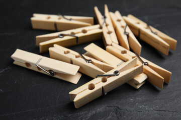 Wooden clothespins on black slate table, closeup