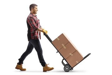 Full length profile shot of a man pushing a hand truck with cardboard boxes