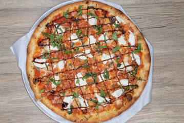 Overhead view of crispy crust on this bruschetta pizza loaded with toppings and drizzled with sauce for presentation