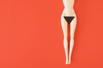 naked doll and a black paper triangle on her hips red background. fenimisi art, hair removal in the...