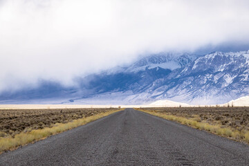 A long, straight road heading into the distant mountains in Idaho.