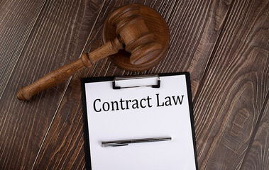 Contract Law text on the paper with gavel on wooden background