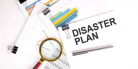 DISASTER PLAN text on white paper on the light background with charts paper