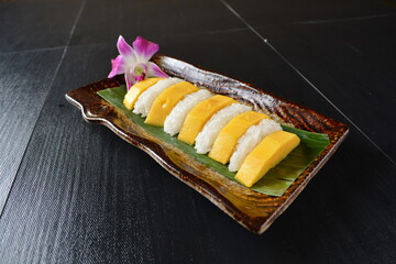 Thai fresh mango fruit with glutinous sticky rice in sweet coconut cream sauce on wood background asian dessert menu