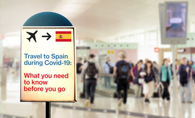 a signal inside an airport that warns about what to know before flying to Spain during the Covid-19 pandemic