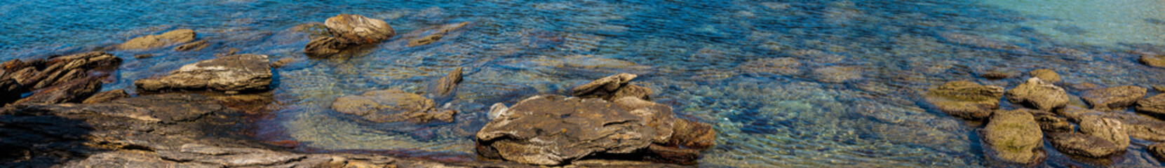 Fototapeta na wymiar panorama of stones and corals in clear waters