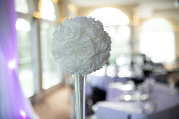Artificial white flower balls with diamonds in glass vase at wedding reception celebartion