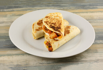 Three BBQ chicken pineapple quesadillas meal on white dinner plate on table