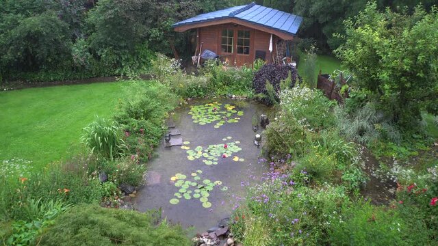 Gartenteich und Gartenhaus im Dauerregen