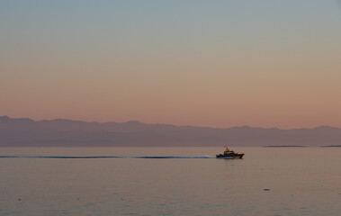 Obraz premium Boat cruising at sunset