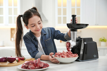 Little girl using modern meat grinder in kitchen - obrazy, fototapety, plakaty