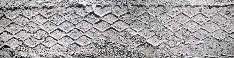 Top view on tire track in the sand. Panorama of tire track, suitable for header or banner. Off road wheel tracks under hard sunlight
