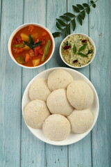 Top view- Indian vegan diet meal- idly with coconut chutney and sambar dish. Healthy vegetarian foods background.