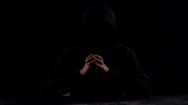 Mysterious Man With Hoodie In Silhouette Isolated On Black Background
