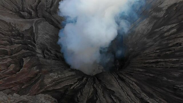 Crater of Mount Bromo with thick toxic steam rising from geothermal vent