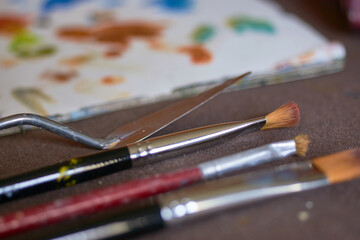 Table with brushes and canvas in an art workshop. Background.