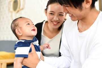 Fototapeta na wymiar 笑顔の父親と母親と子（赤ちゃん）