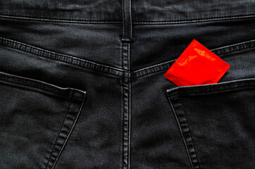 Condom in back side of jeans pocket for anal safe sex, world sexual health and aids day concept.