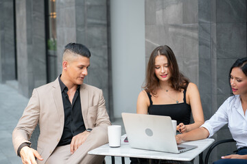 Group of Business People Drinking Coffee and Discussion with Laptop Computer at Coffee Shop in Breaking time