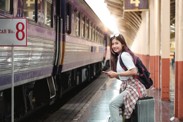 Portrait attraction asian Woman traveler tourist sitting with luggage at train station. Active and...