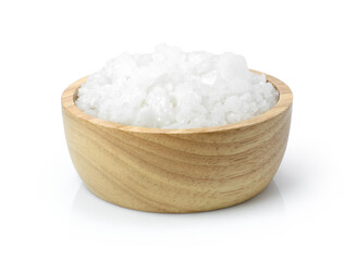 Closeup coarse or rock natural sea salt in wooden bowl isolated on white background. Clipping path. 