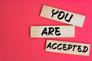 YOU ARE ACCEPTED text on a wooden cubes on a red background