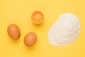 Wheat flour and chicken eggs on a bright yellow background.