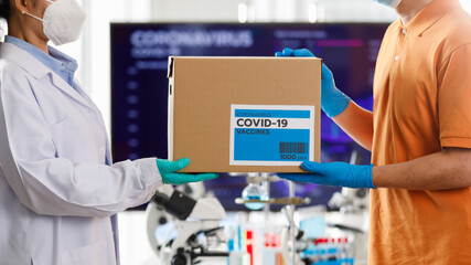 Asian man handling a box of Covid 19 vaccine to Asian doctor in hospital. Concept for Covid 19 vaccination
