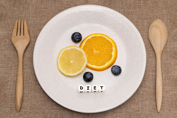 Slices of orange and lemon with blueberries on a white ceramic plate.