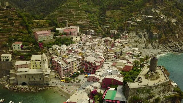Cinematic 4K aerial drone dolly out footage of Doria Castle and Vernazza in The Cinque Terre, a breathtaking tourist destination, panoramic coastal village within Liguria, in the northwest of Italy