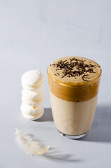 Dalgon coffee in a high glass with foam and chocolate chips on a gray background