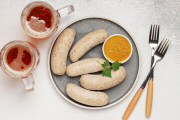 Munich white sausage with sweet mustard and beer in glass on paper plate. Top view