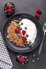 Healthy breakfast with baked granola and greek yogurt. Assorted fresh berries. Vertical photo
