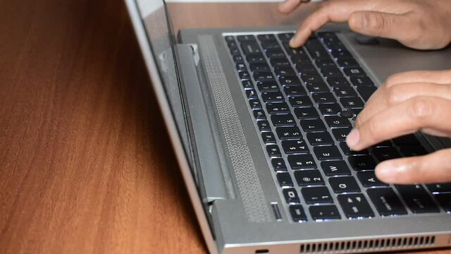 A shallow focus of a person working and typing on a laptop keyboard in HD