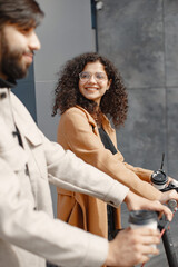 Interracial young couple with scooters in the city background