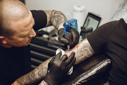 Man doing a tattoo in a tattoo salon