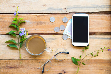 mobile phone ,cash ,coins and hot coffee of lifestyle woman arrangement flat lay style on background wooden