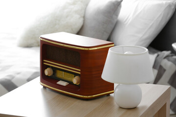 Retro radio receiver on table in bedroom, closeup