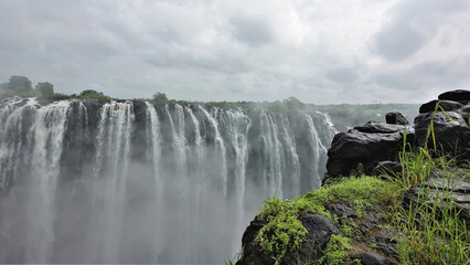 The majestic Victoria Falls. Powerful streams of water plunge into the abyss. Fog over the gorge....