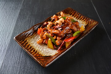 stir fried chicken meat with vegetable, cashew nut and dried chilli in sweet sauce on wood...
