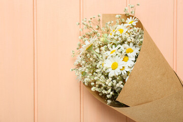 Bouquet of beautiful chamomile flowers on color wooden background, closeup